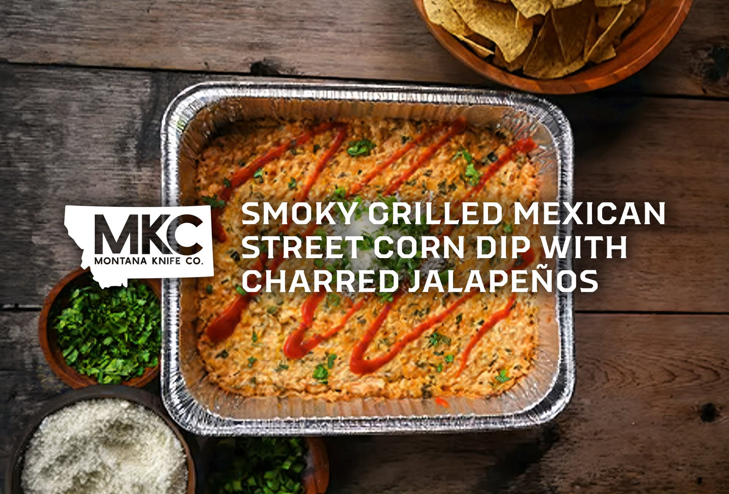 Creamy Mexican street corn dip in foil pan with hot sauce drizzles, surrounded by chips and fresh toppings.