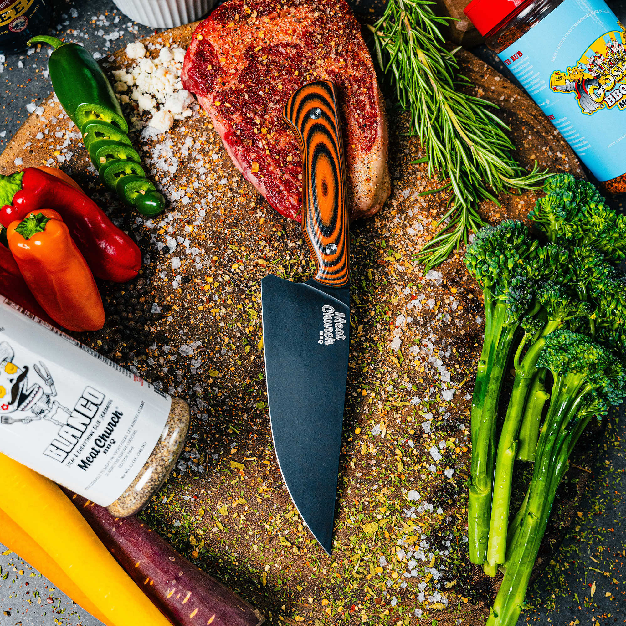 Montana Knife Company's Meat Church Chef Knife on a wooden cutting board with fresh vegetables and spices.