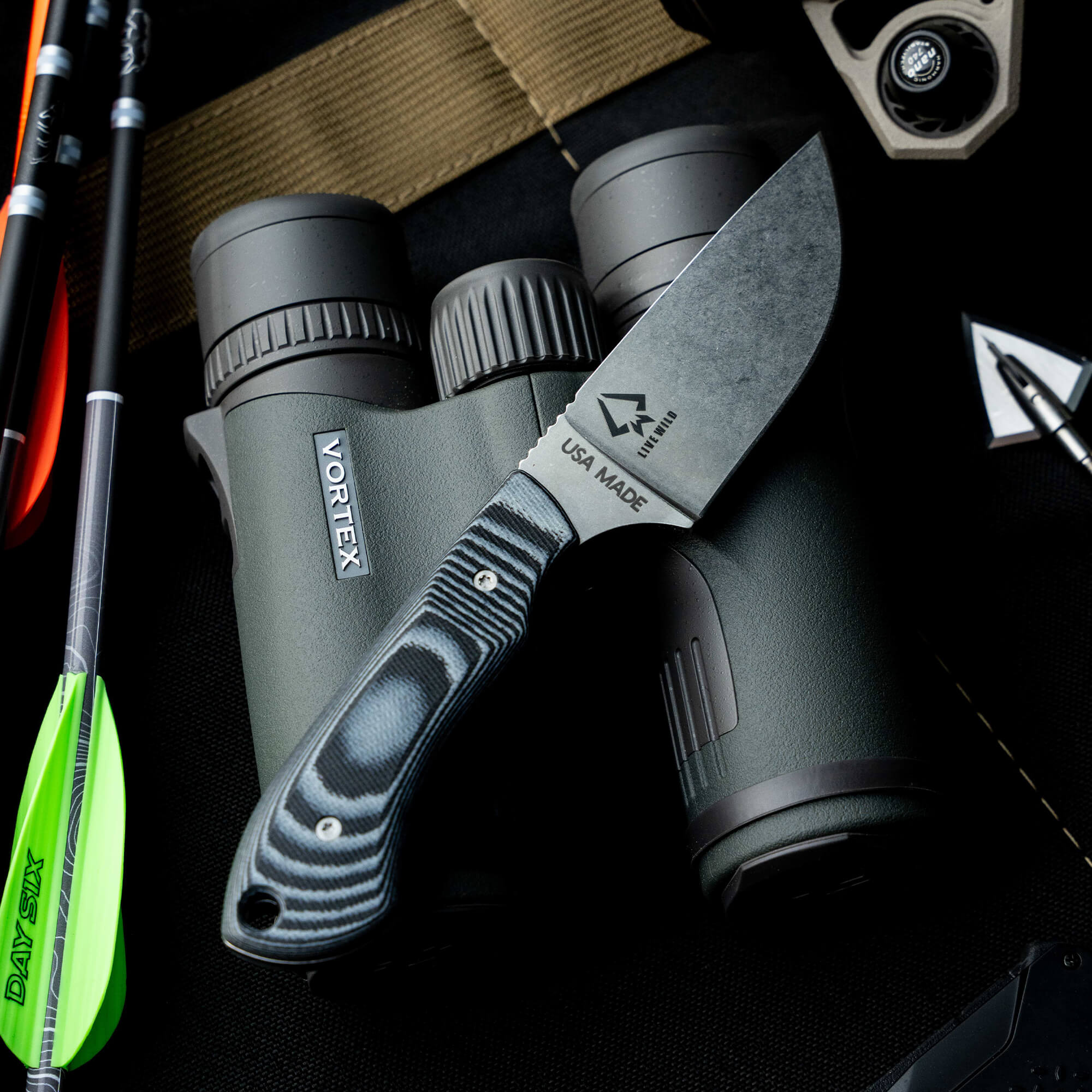 Montana Knife Company's Elk Knife displayed with binoculars and archery gear, showcasing its rugged design and American craftsmanship.