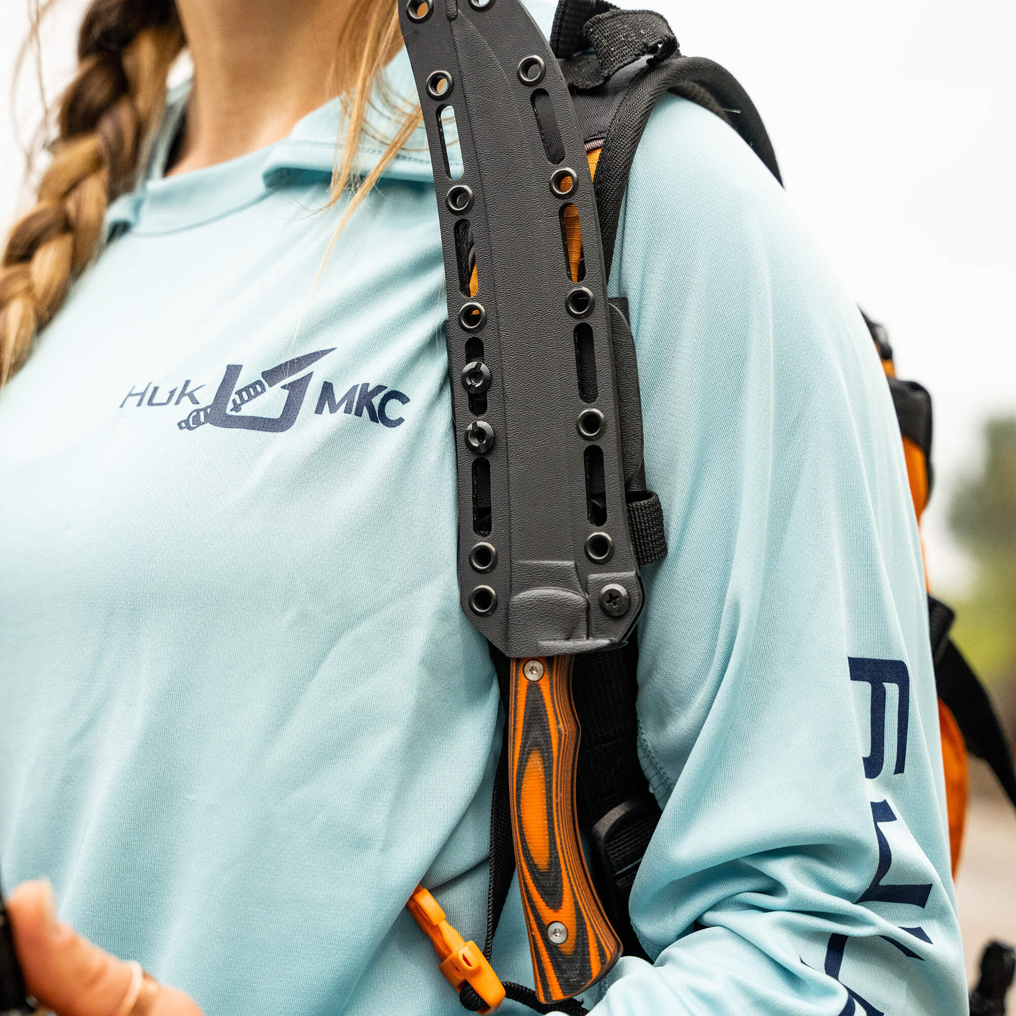 HUK Flathead Fillet knife attached to a backpack strap, showcasing its ergonomic design and durability for fishing enthusiasts.