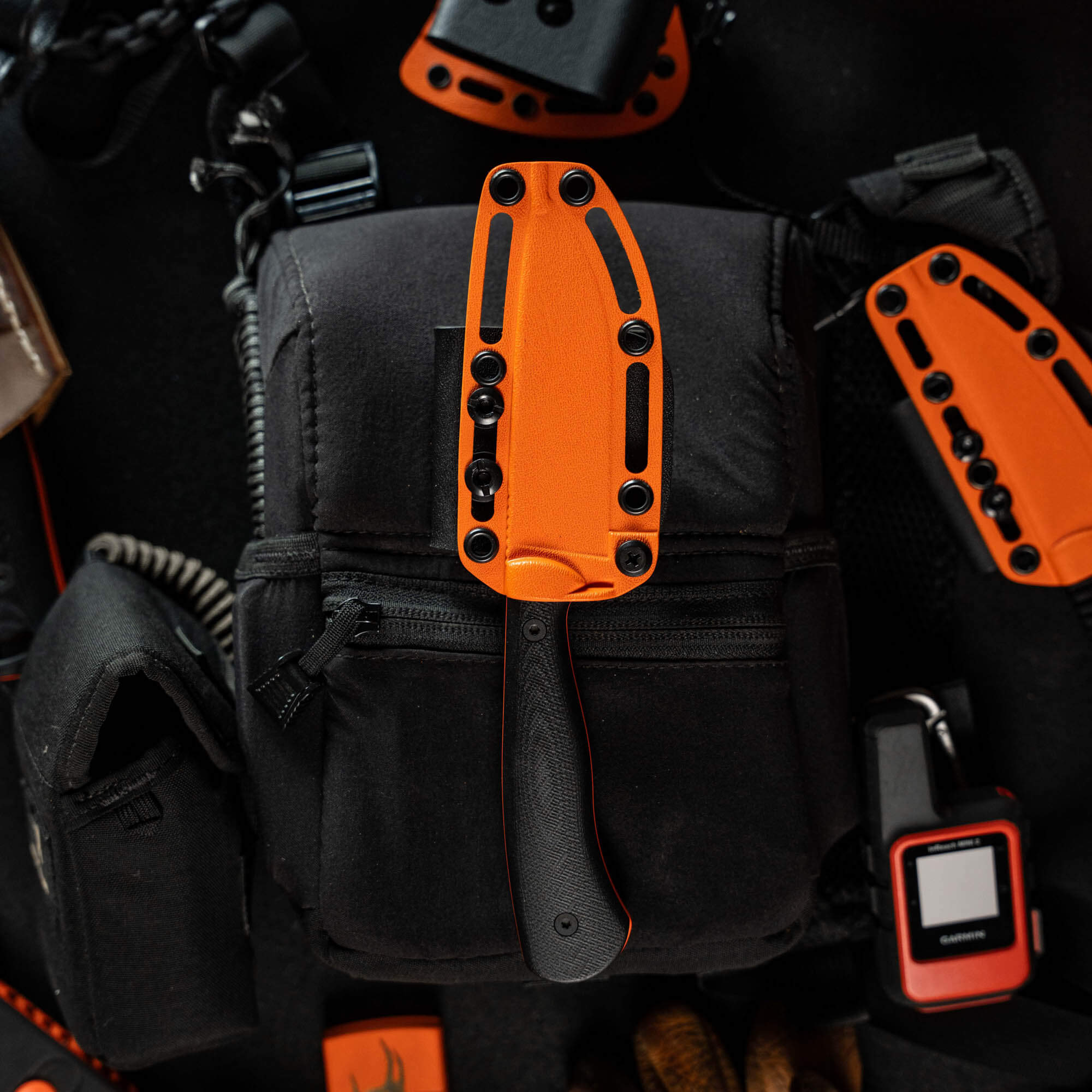 Additional Kydex sheath for the Whitetail knife, featuring a vibrant orange design, placed on a black tactical bag.