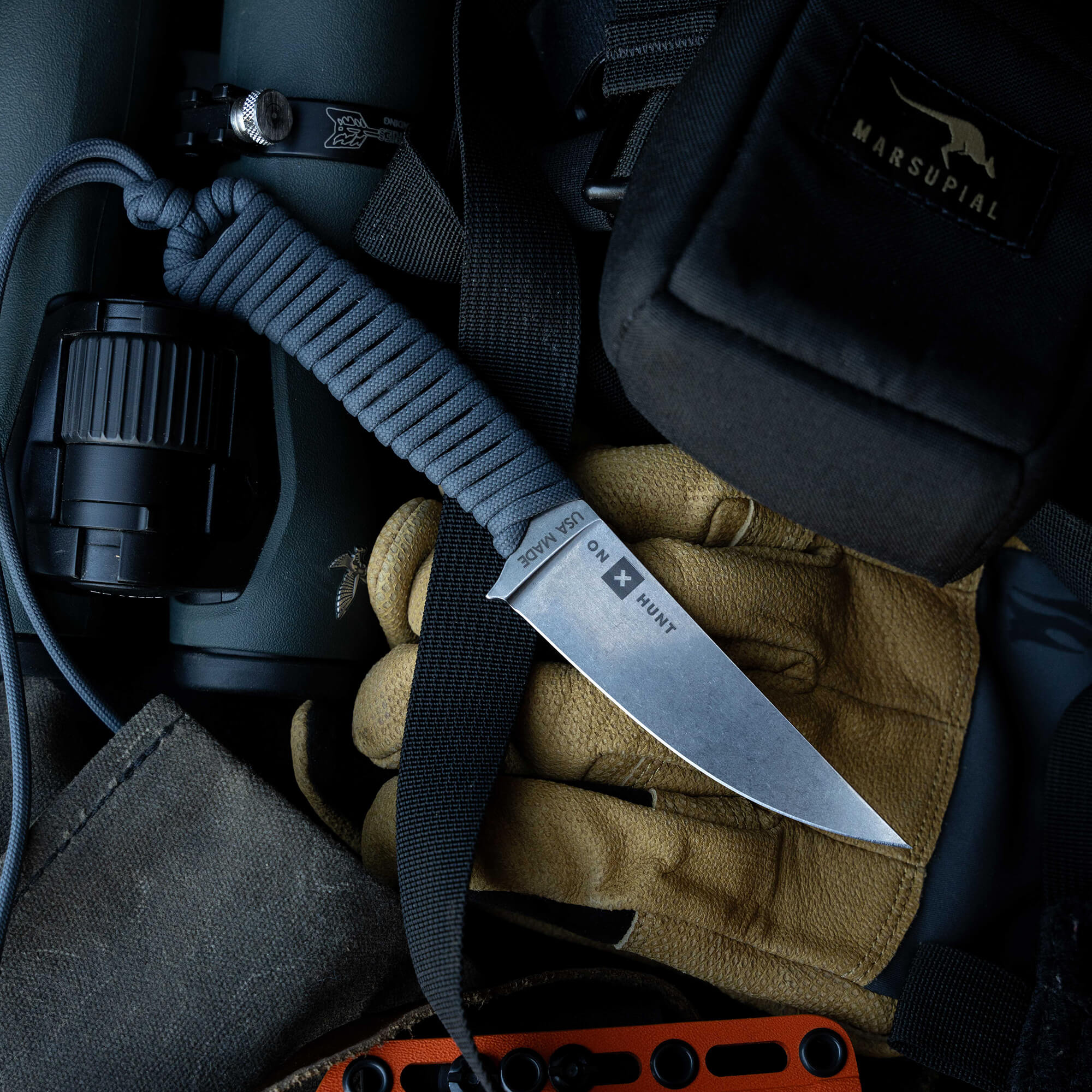 ONX Hunt Magnacut Speedgoat 2.0 knife resting on gloves and gear, showcasing its rugged design for outdoor use.