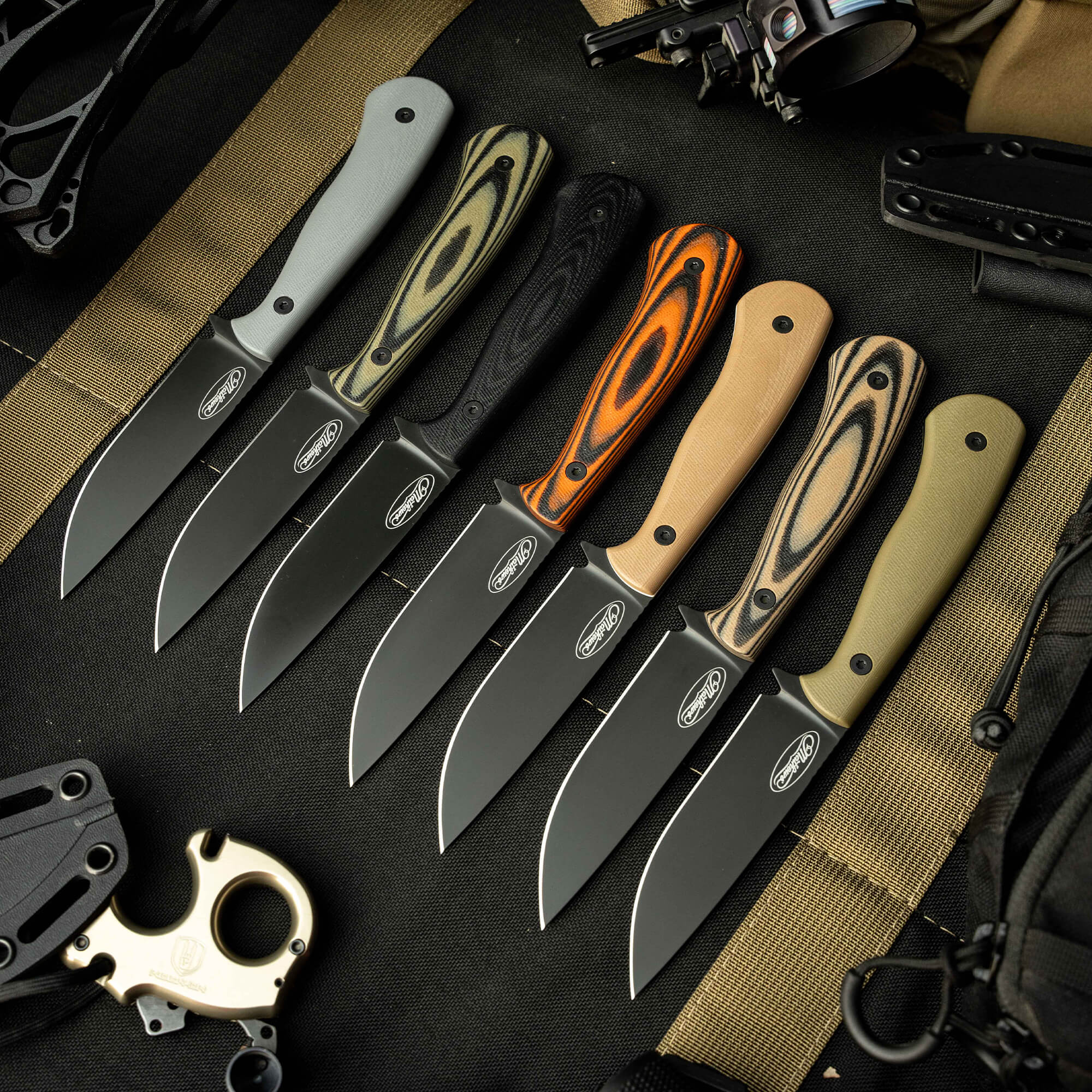 A collection of six MKC Whitetail knives featuring various handle colors and patterns, displayed on a tactical background.