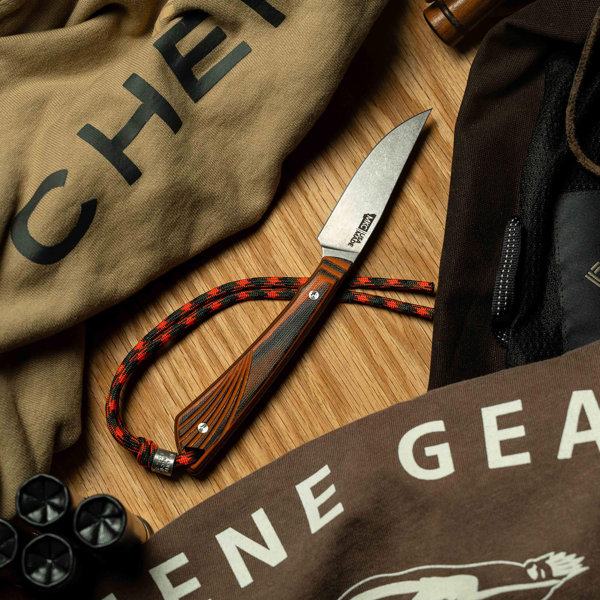 Montana Knife Company's CHÊNE Freezout knife displayed on fabric with a rugged design, showcasing its wood handle and blade.