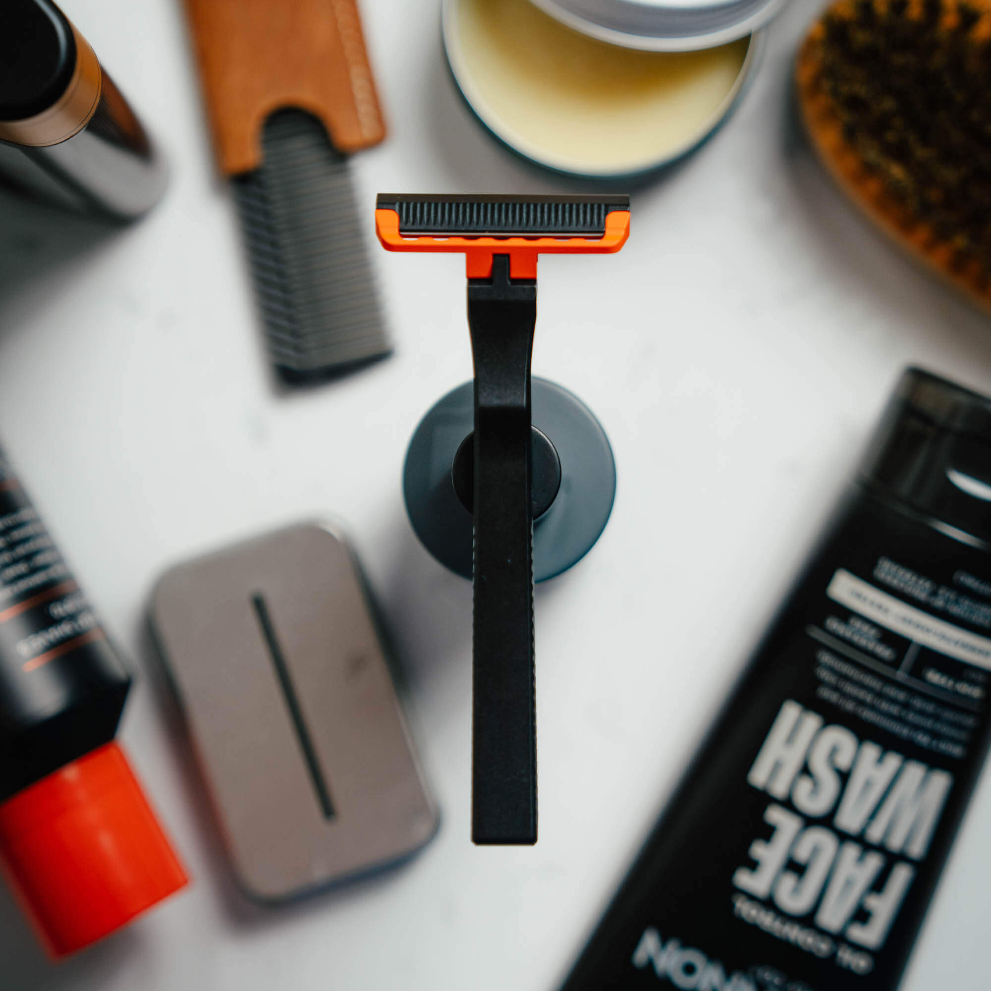MKC X PROOF EDC Razor 2.0 displayed on a countertop surrounded by grooming products, showcasing its sleek design.