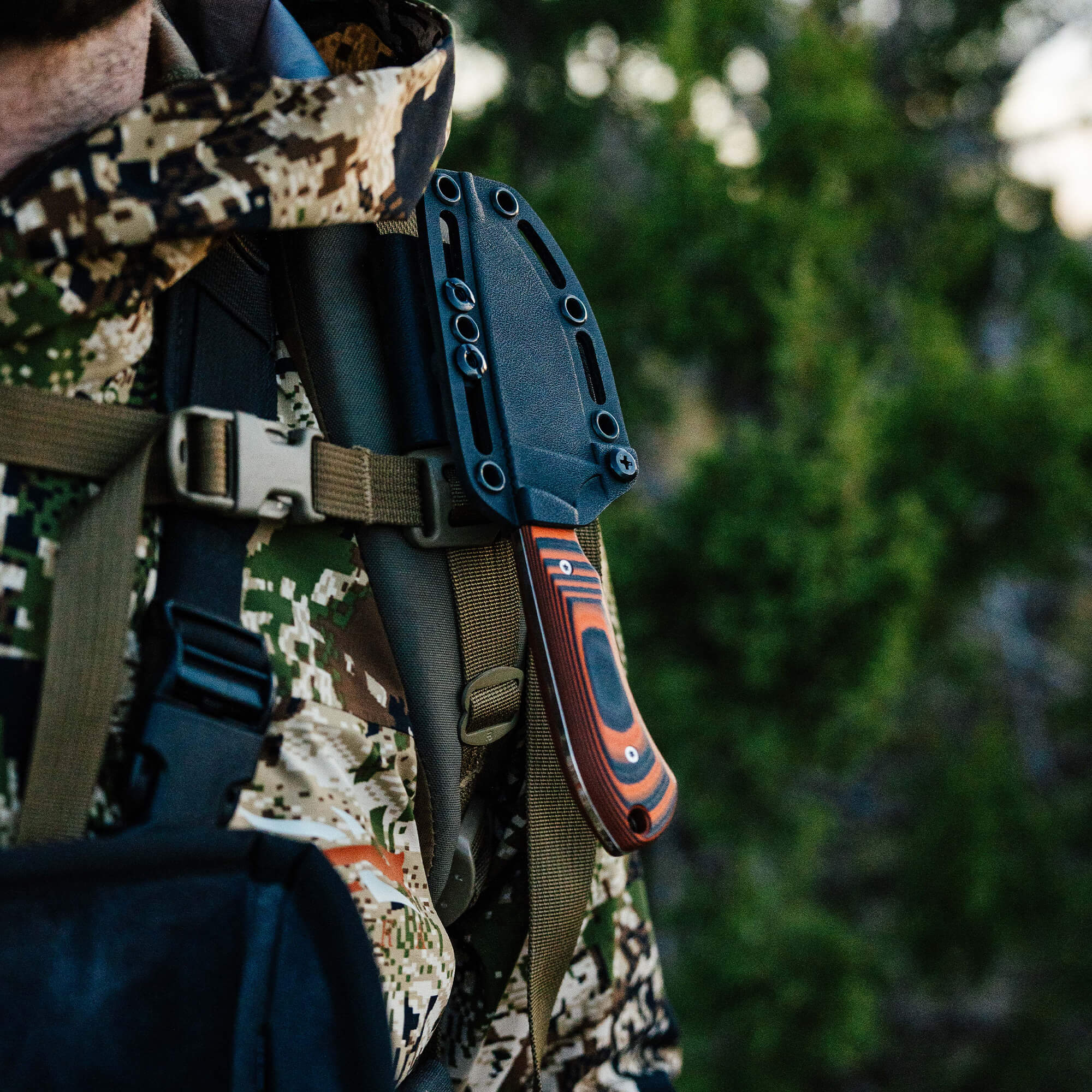 Montana Knife Company's Live Wild Elk Knife secured in a sheath on a hunter's shoulder, showcasing its rugged design.