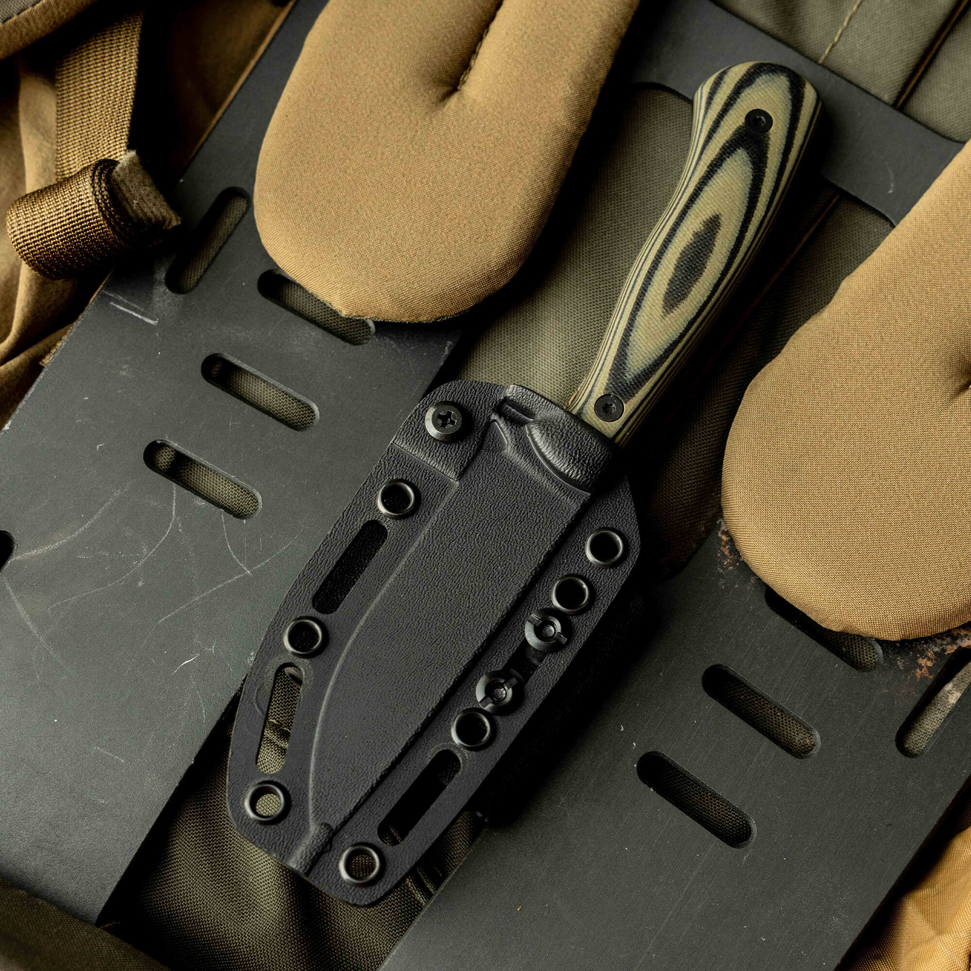 Mathews Archery MKC Whitetail knife in a black sheath, showcasing a durable handle and tactical design for outdoor use.