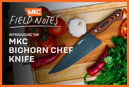 Bighorn Chef Knife on wooden cutting board with tomatoes, garlic, chili peppers and cilantro.