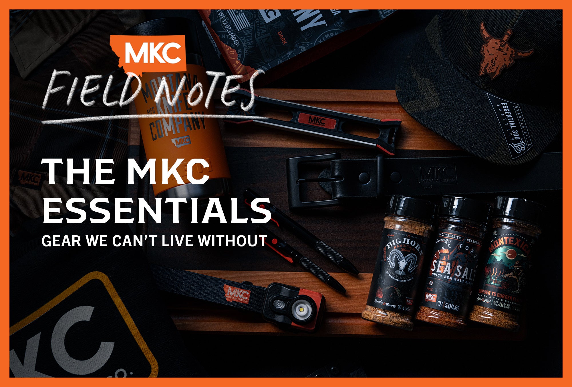 Various pieces of MKC gear laid out on a wooden tabletop in a dimly lit room.