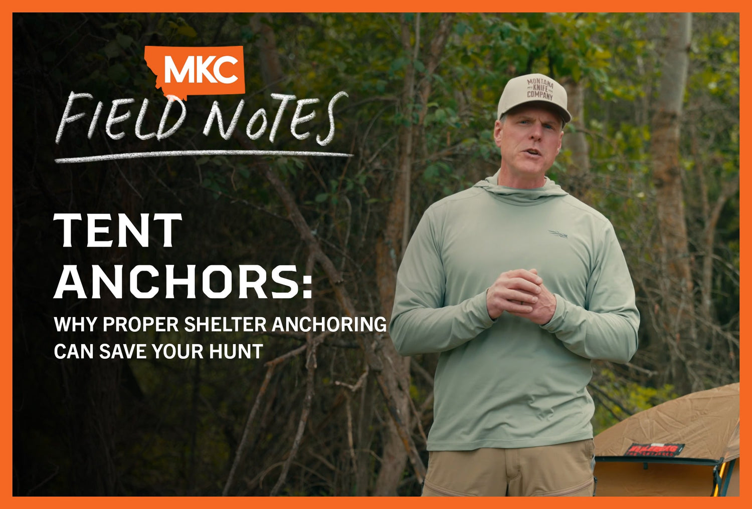 Man standing outdoors beside a tent in a remote backcountry setting, illustrating proper tent anchor setup.