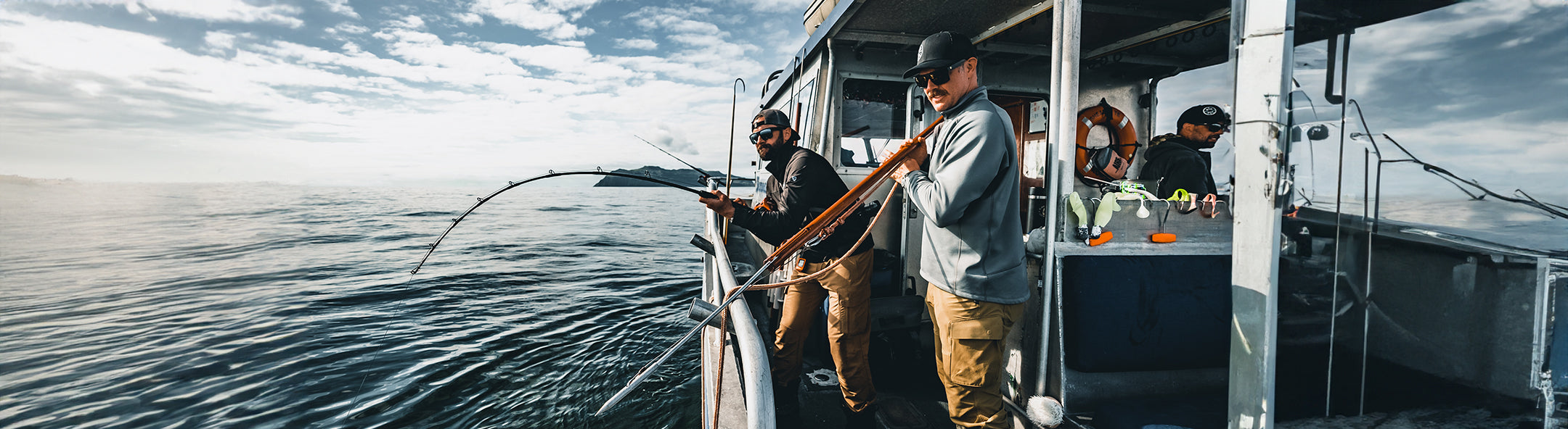 Fisherman on a boat with a fish on