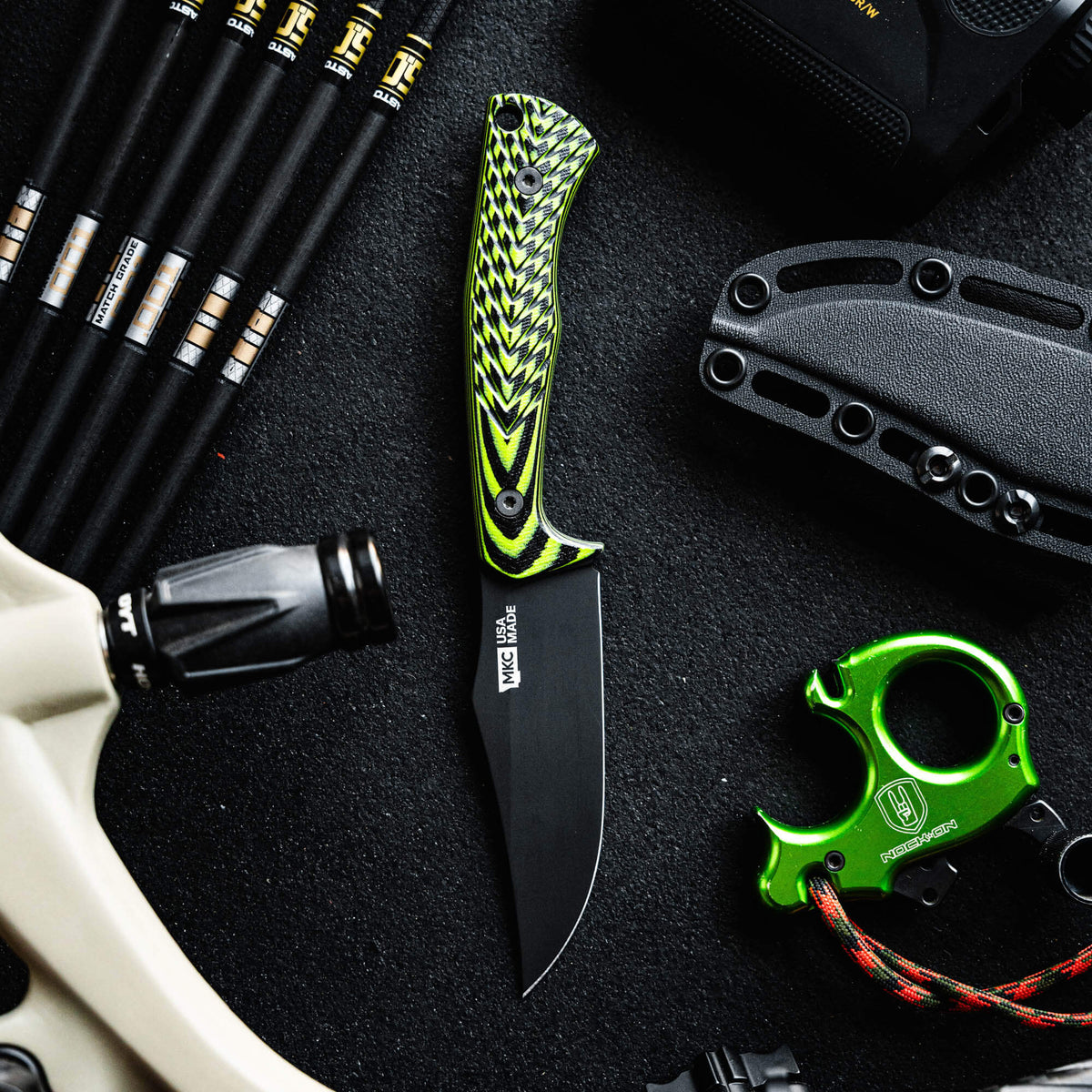 Triumph Pro knife in neon green and black, featuring a sleek blade and textured handle, surrounded by outdoor gear.
