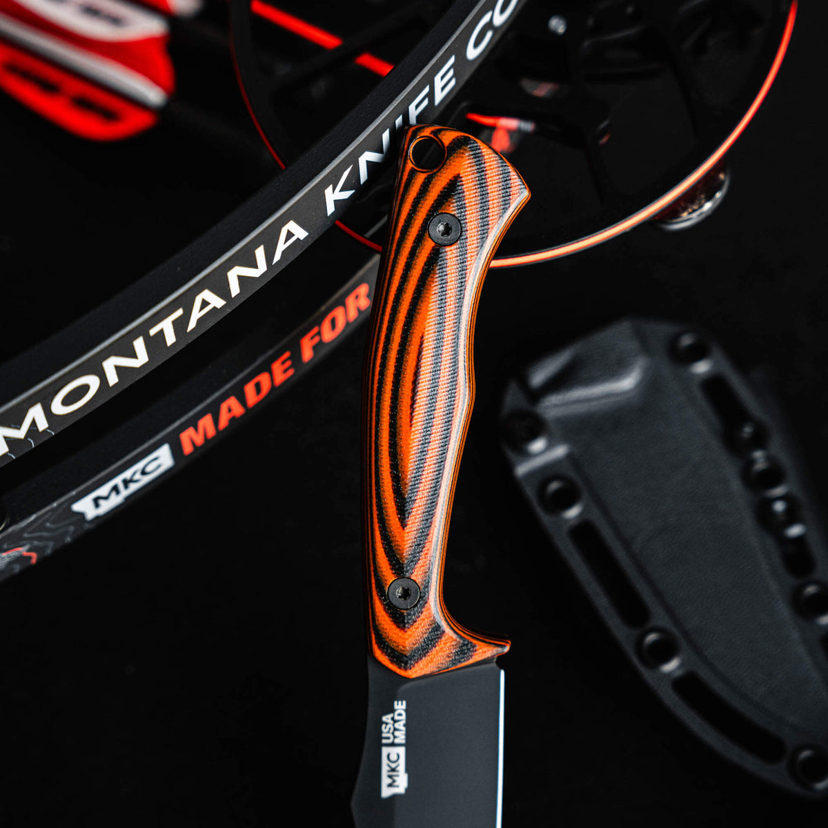 Close-up of the Triumph Pro knife featuring an orange and black handle, showcasing its ergonomic design and craftsmanship.