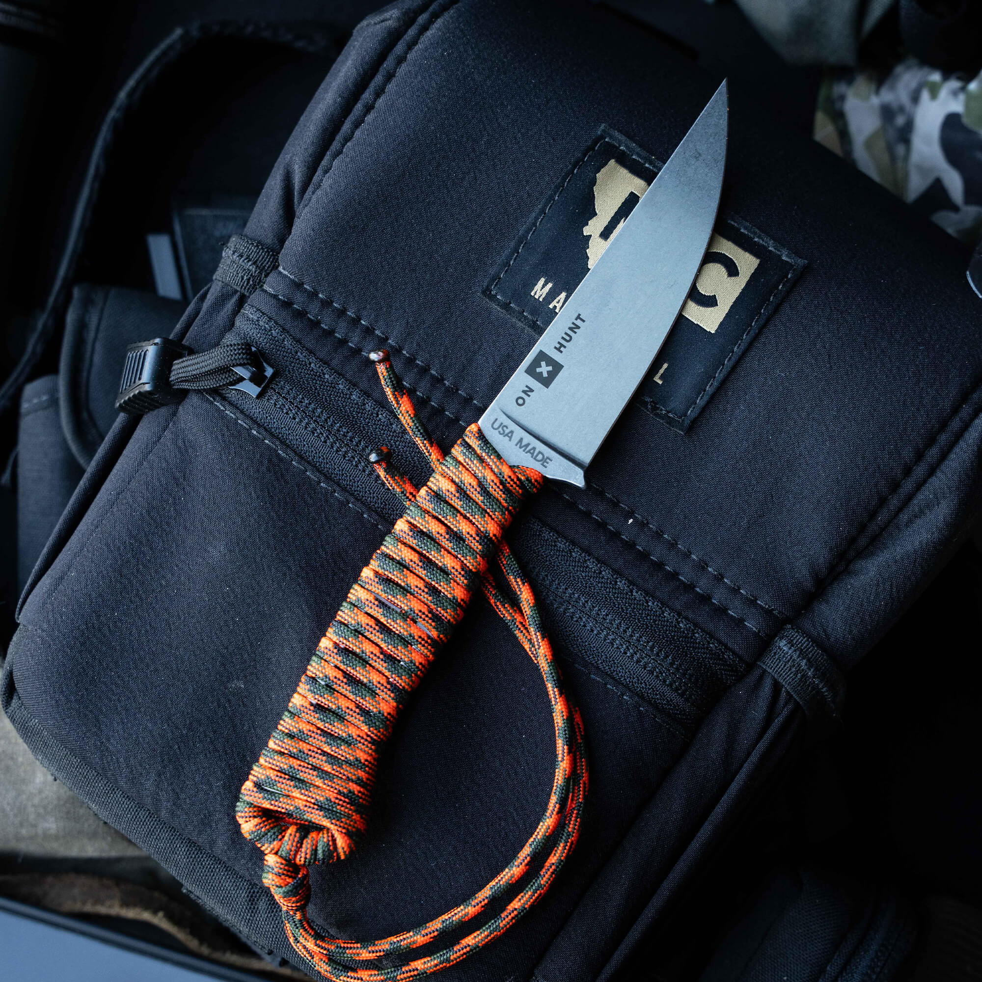 ONX Hunt Magnacut Speedgoat 2.0 knife with a durable handle, resting on a black tactical bag, showcasing its American-made quality.