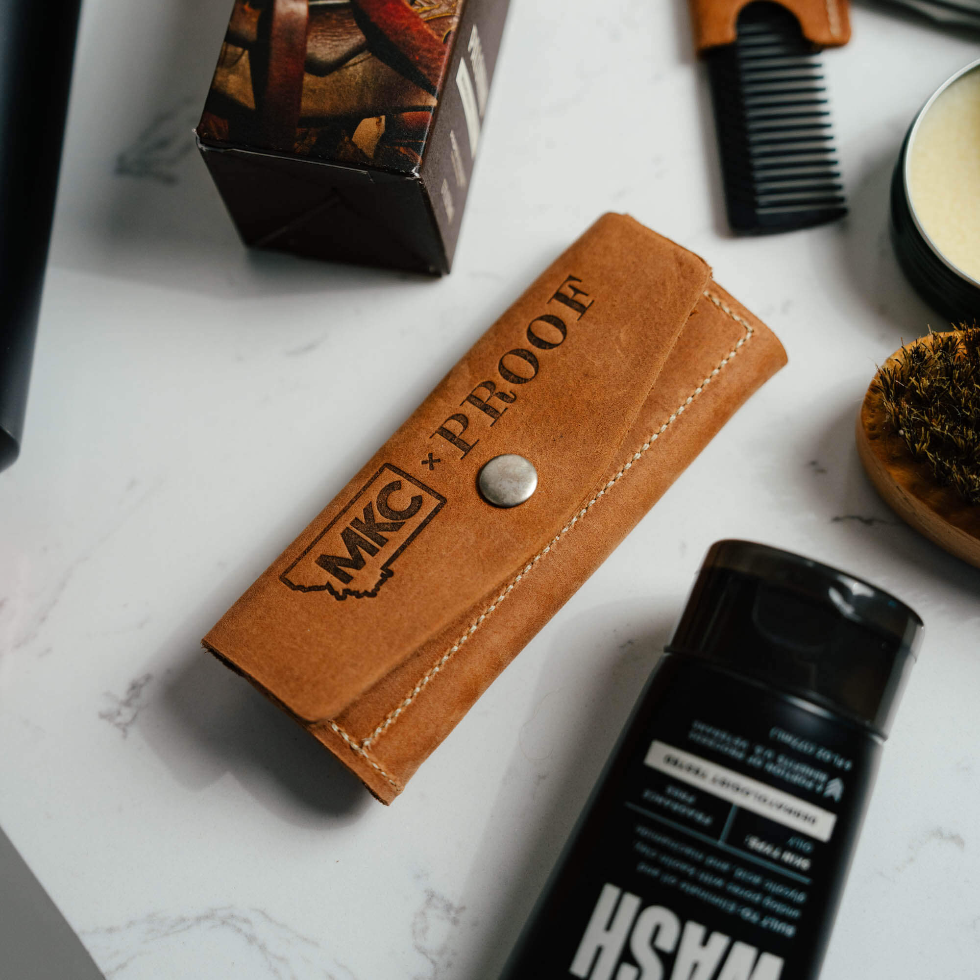 MKC X PROOF EDC Razor 2.0 in a leather case, showcasing a rugged design for everyday carry and outdoor use.