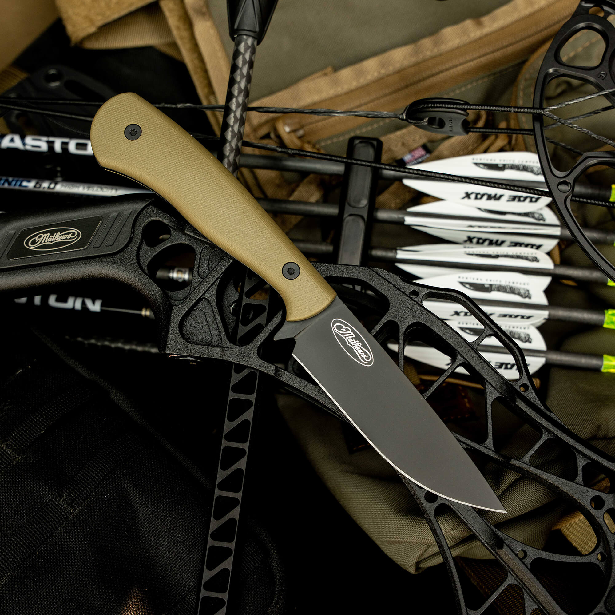 Mathews Archery MKC Whitetail knife resting on a bow, showcasing its sleek blade and ergonomic handle design.