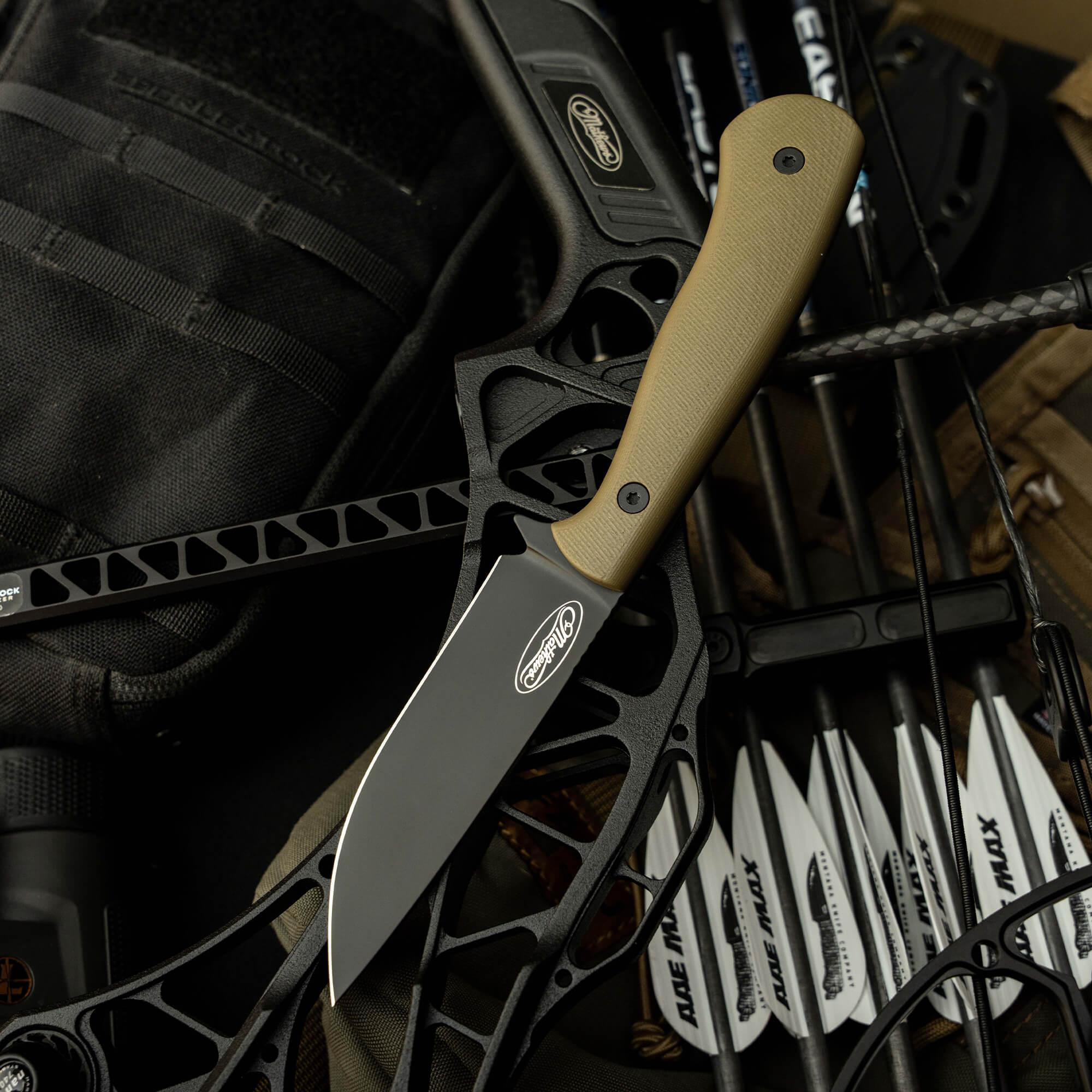 Mathews Archery MKC Whitetail knife on a bow with arrows, showcasing a sleek design and durable materials for hunting.