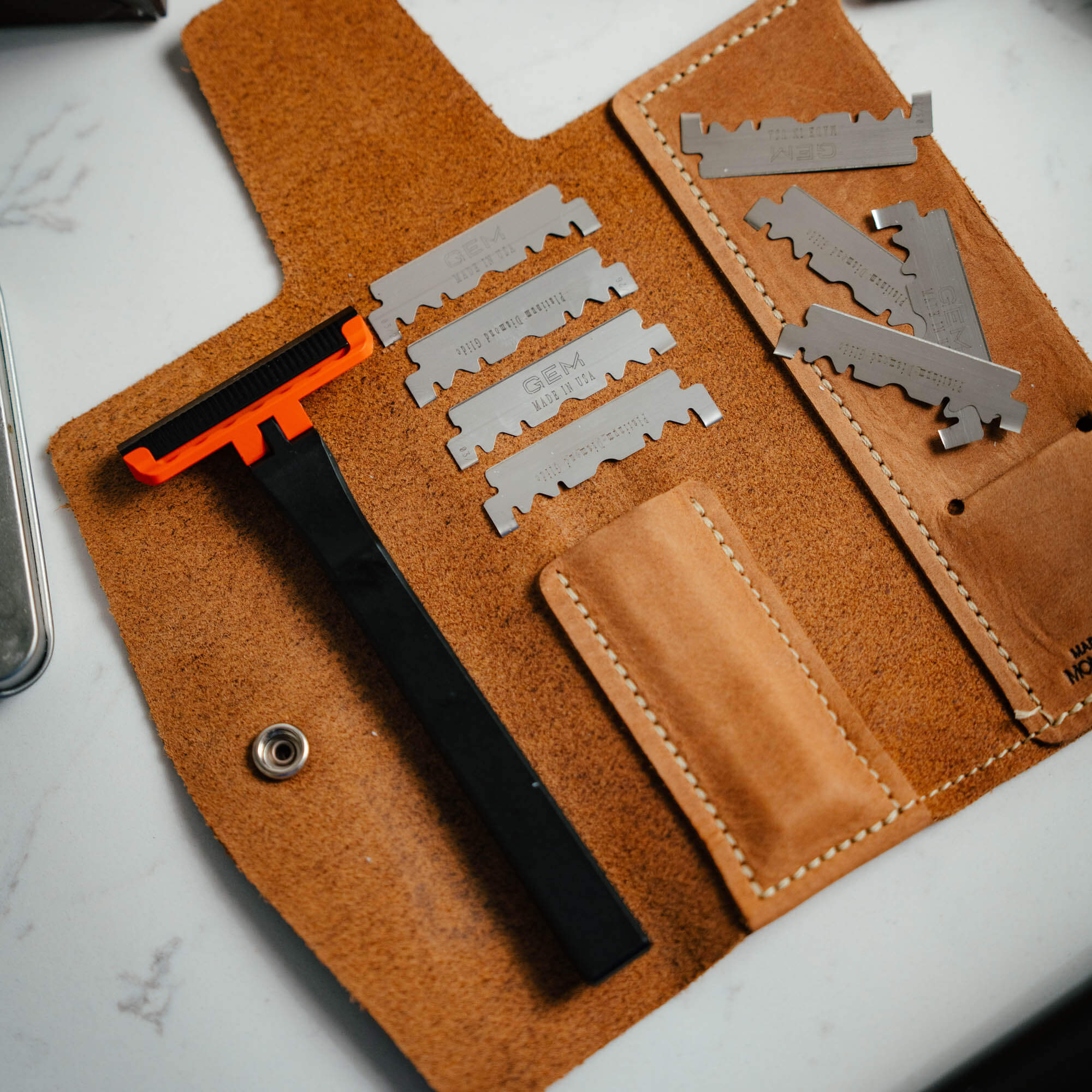 MKC X PROOF EDC Razor 2.0 with interchangeable blades in a leather case, designed for everyday carry and utility.
