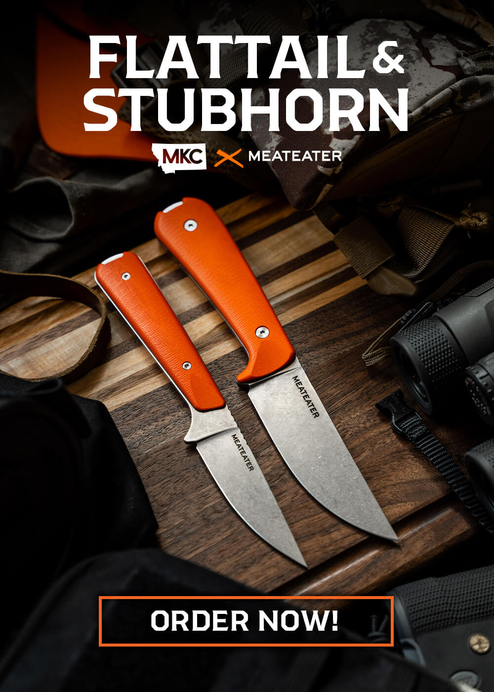 Image of two knives with orange handles on wood surface